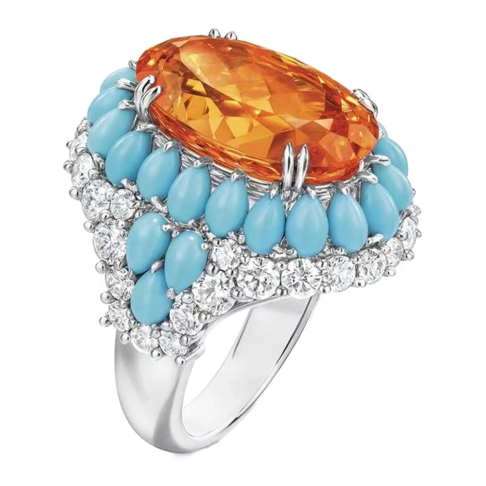 Ring with orange gemstone and turquoise stones on a white background, featuring the brand 'KQDANCE'.