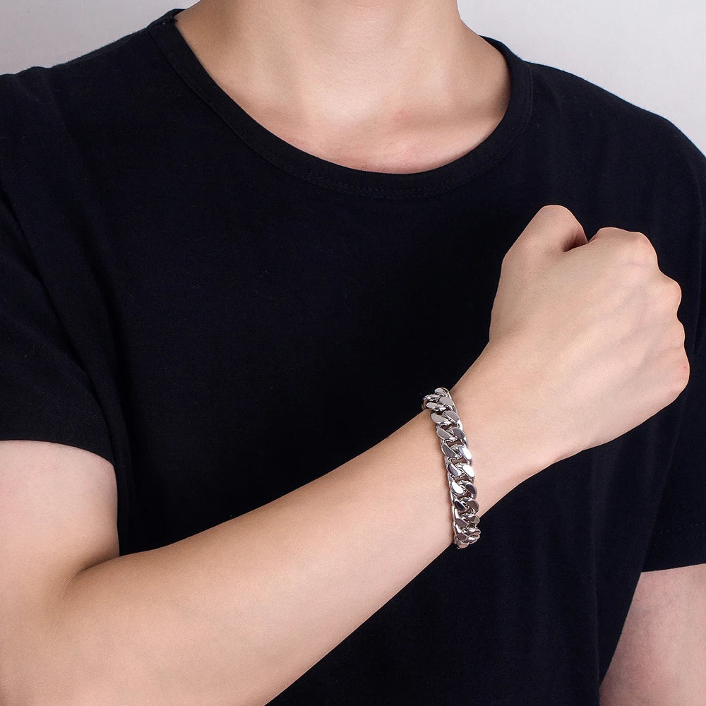 Person wearing a silver bracelet on a plain background