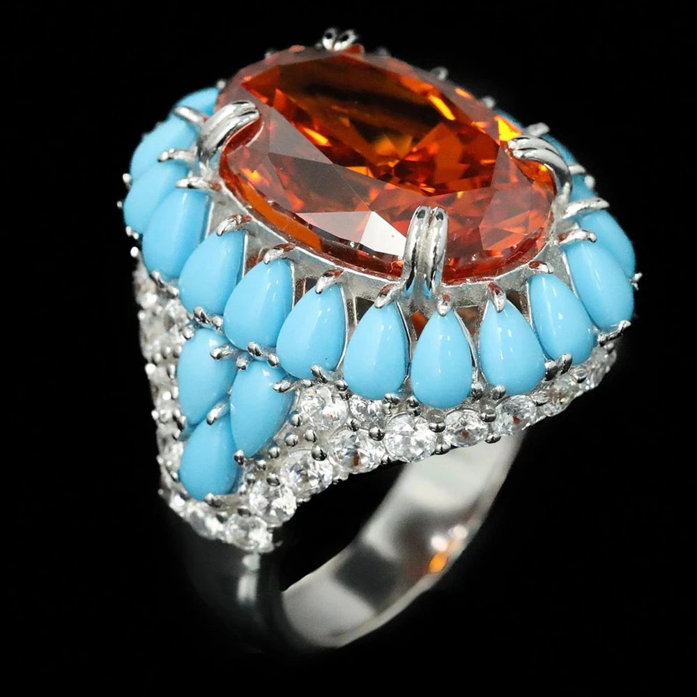 Ring with orange gemstone and turquoise stones on a black background