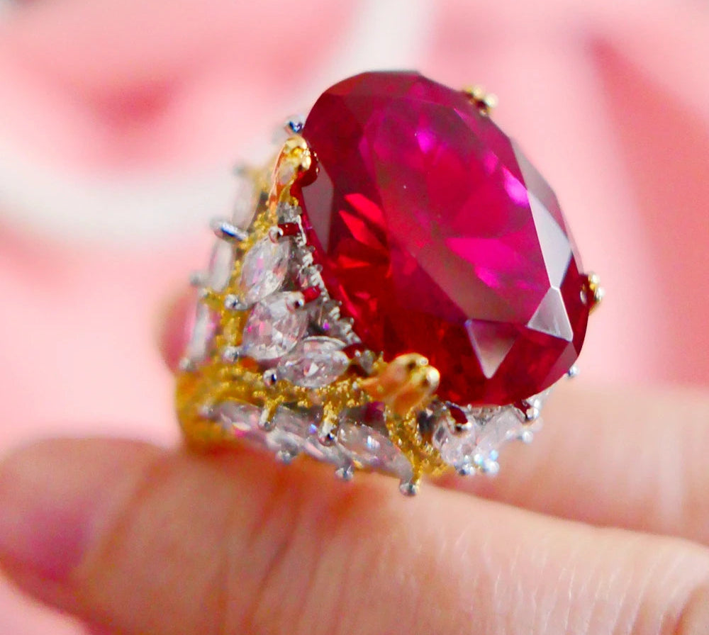 Ring with a large red gemstone and smaller diamonds on a blurred background