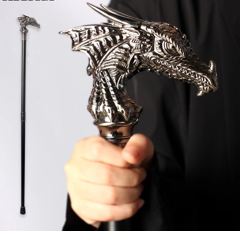 Decorative walking cane with dragon head design held by a person against a black background.