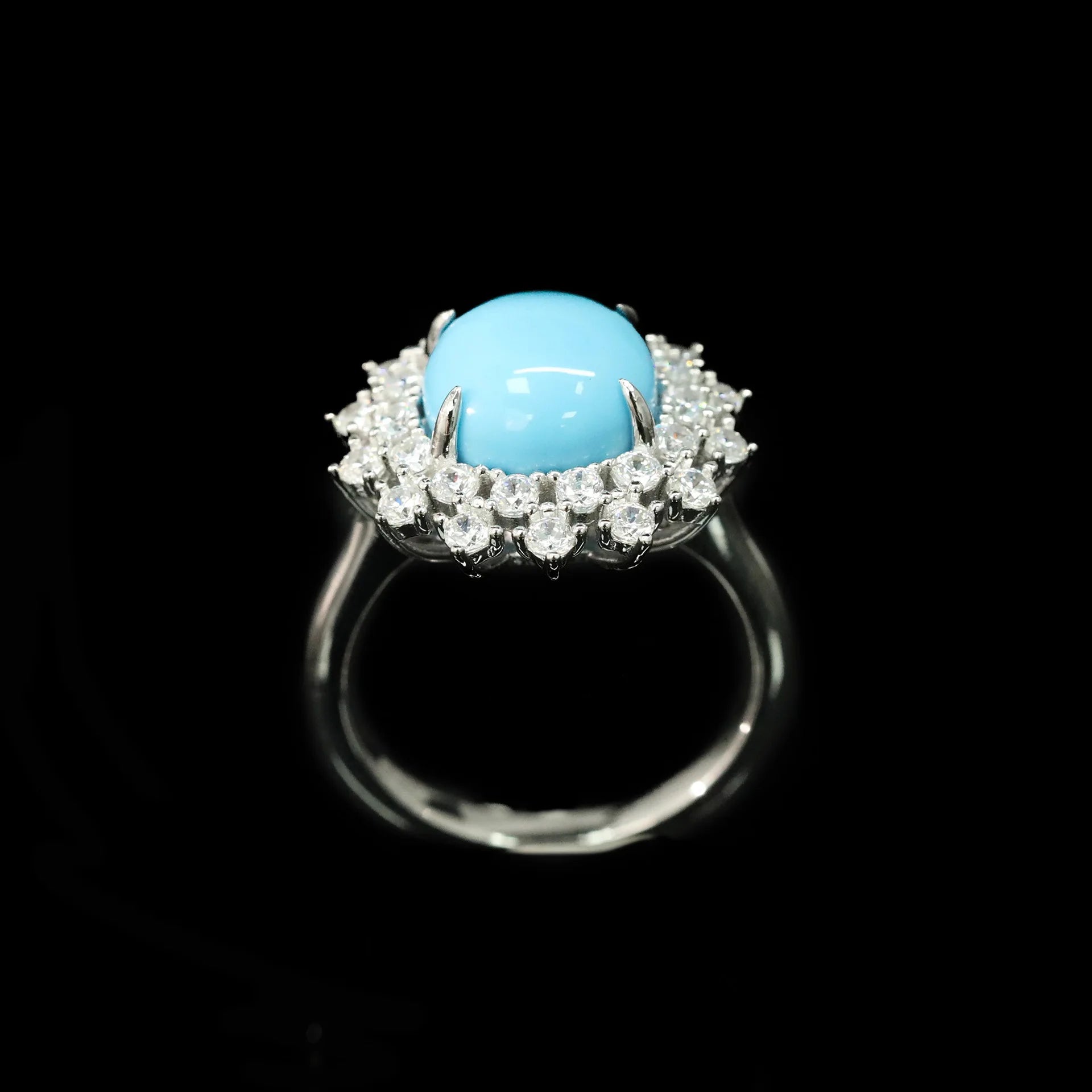 Ring with a turquoise gemstone and diamond-studded band on a black background